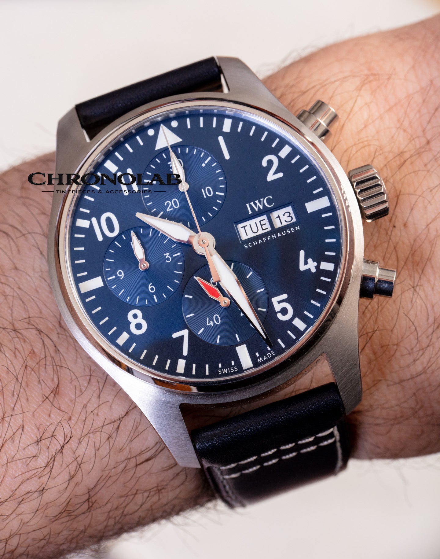 Close-up of the IWC IW388101 blue dial featuring day-date display, rhodium-plated hands, and luminous Arabic numerals
