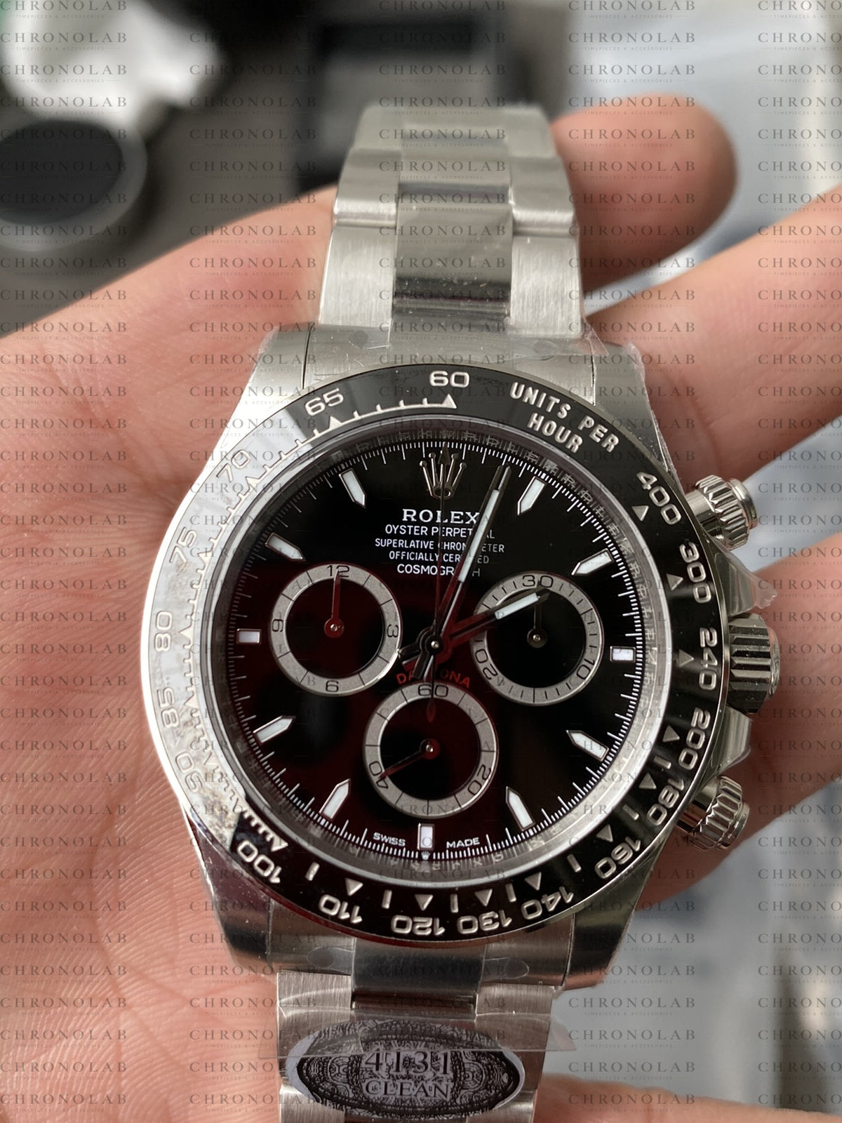 Front view of Rolex Daytona 126500LN Black Dial on display stand with factory protective plastics from Clean Factory